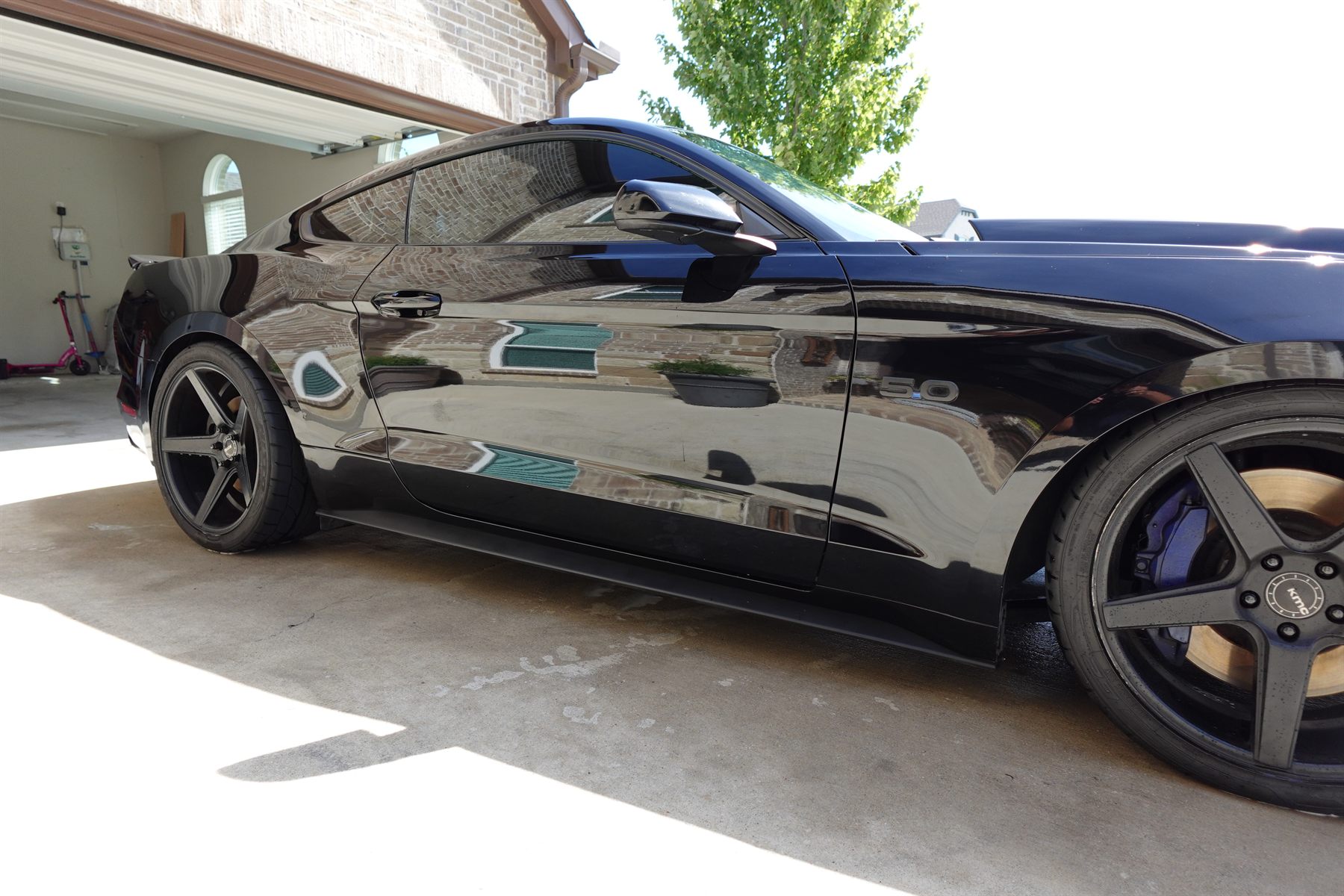 Mirror-gloss black Mustang finished in a client's driveway